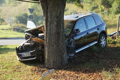 VW schanzt  auf Kreisverkehr und kracht gegen Baum.